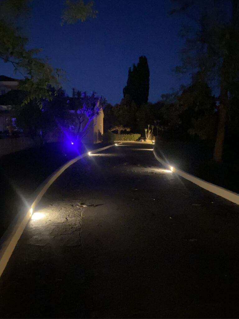Allée de jardin éclairée par des spots encastrés à la nuit tombée