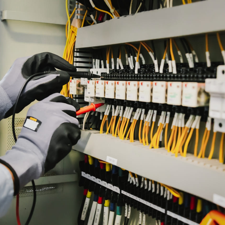 Électricien intervenant dans une armoire électrique industrielle