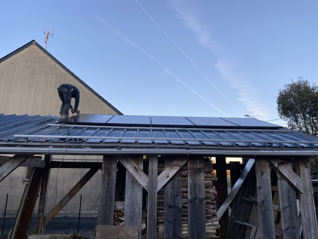 Installateur fixant des panneaux photovoltaïques sur une charpente en bois