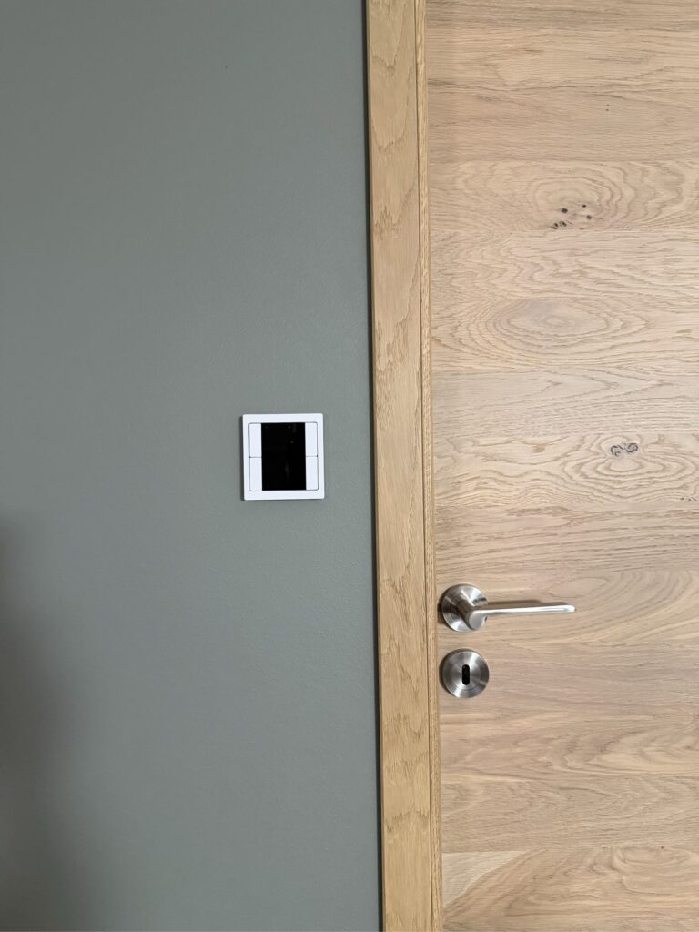 Commande domotique murale encastrée près d’une porte